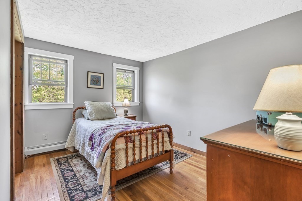 31 Washington Street Mendon, MA 01756 - Photo 32 of 40 a bedroom with a bed and a lamp with wooden floor