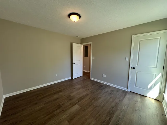 an empty room with wooden floor and closet