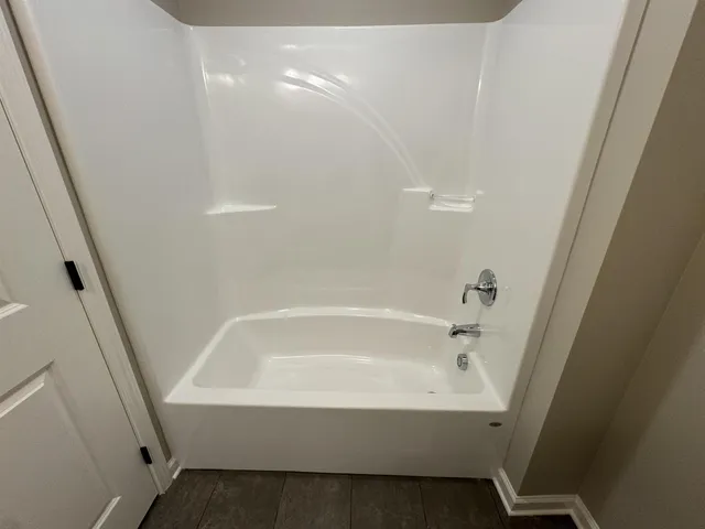 a white bath tub sitting next to a white sink and vanity