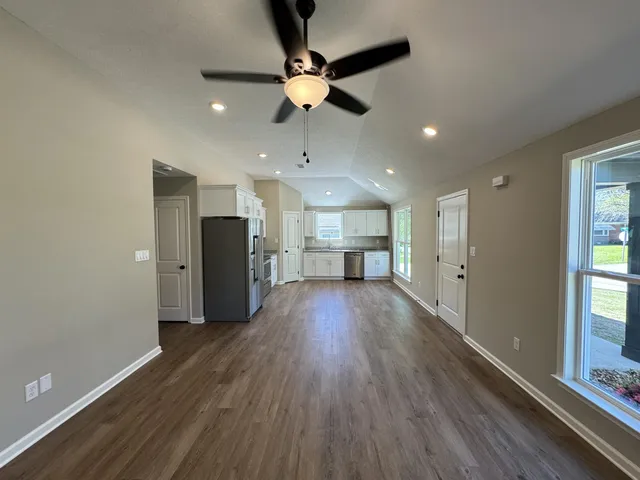 a view of empty room with wooden floor and window