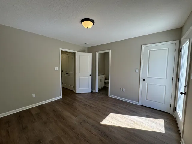 an empty room with wooden floor and closet