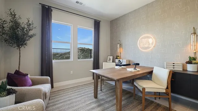 a view of a workspace room with furniture and window