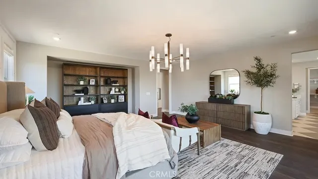 a large bedroom with a bed and wooden floor