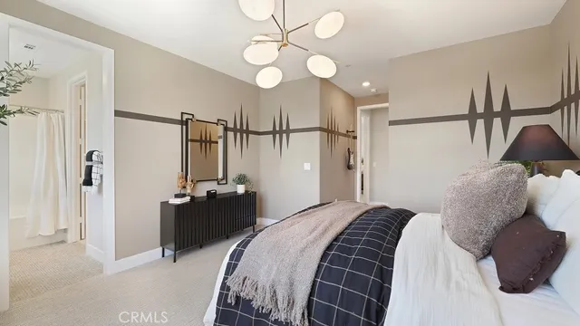 a bedroom with a bed mirror and a chandelier