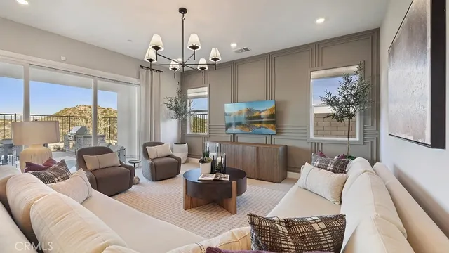 a living room with furniture a chandelier and a dining table