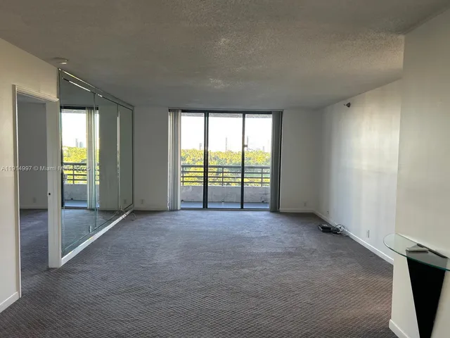 a view of empty room with windows and cabinet