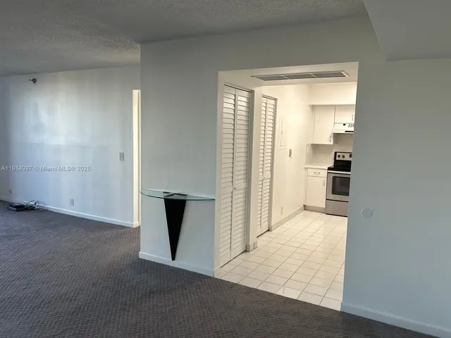 a view of kitchen with refrigerator and window