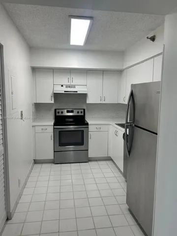 a kitchen with stainless steel appliances a refrigerator and a stove top oven