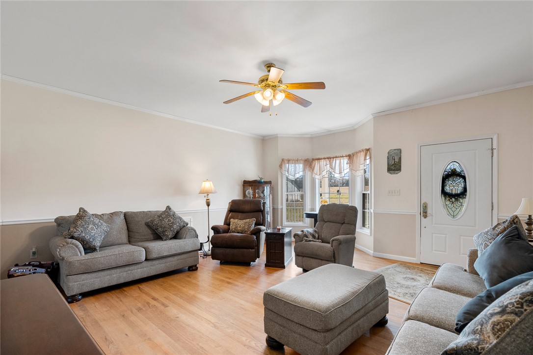 2803 Trail Road Belton, SC 29627 - Photo 5 of 48 This inviting living room features elegant crown molding and rich hardwood flooring, creating a refined atmosphere.