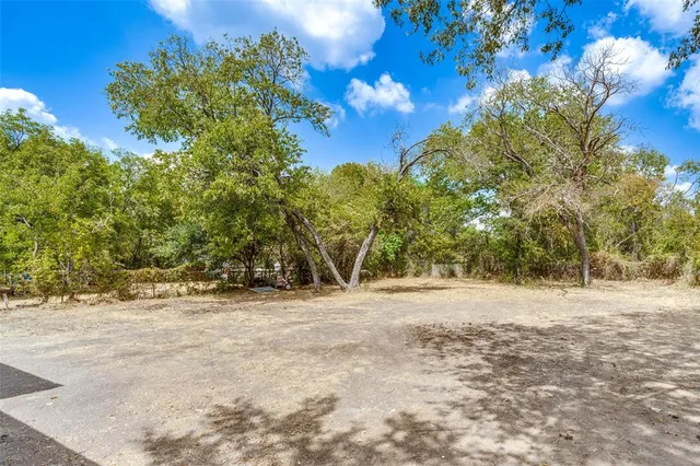 a view of dirt road with a building in the background