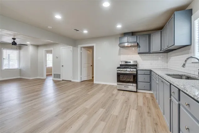 a kitchen with granite countertop a stove and a sink
