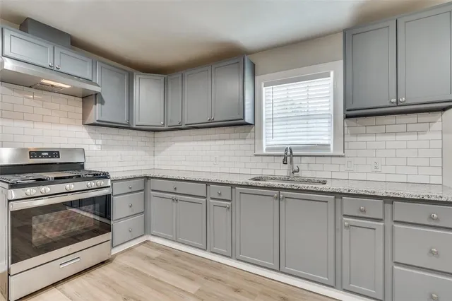 a kitchen with granite countertop cabinets stainless steel appliances and sink