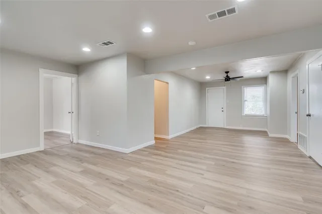 a view of empty room with wooden floor