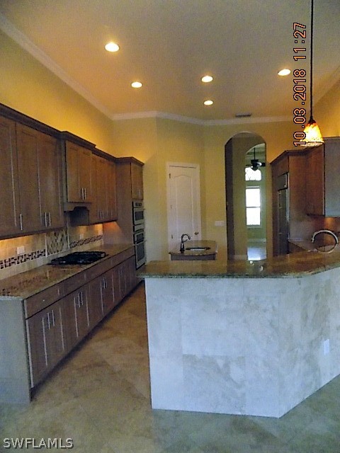 19220 La Serena Drive Estero, FL 33967 - Photo 25 of 27 a large kitchen with kitchen island granite countertop wooden cabinets a sink and dishwasher