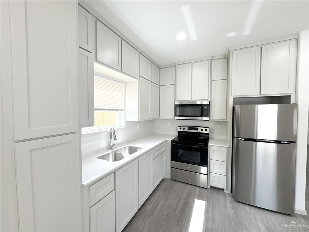 740 North Alamo Road, Unit 18 Alamo, TX 78516 - Photo 9 of 18 a kitchen with a refrigerator a stove a microwave and cabinets