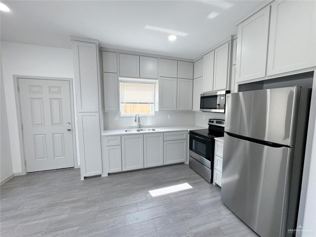 740 North Alamo Road, Unit 18 Alamo, TX 78516 - Photo 10 of 18 a kitchen with white cabinets and white appliances