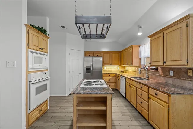 a kitchen with stainless steel appliances granite countertop a stove and a refrigerator