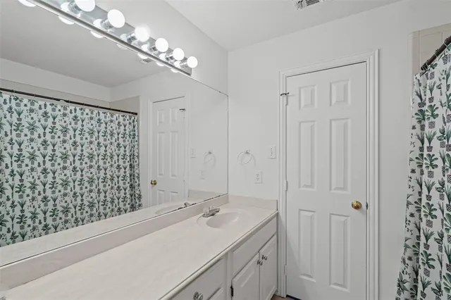 a bathroom with a sink a large mirror and shower