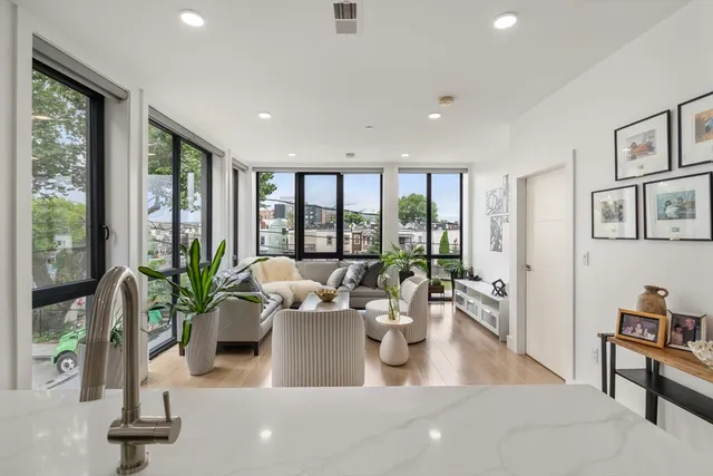 a living room with furniture potted plant and a large window