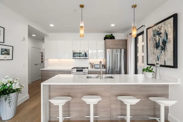 a kitchen with stainless steel appliances granite countertop a kitchen island a table and chairs in it