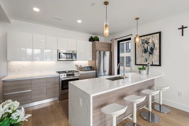 a kitchen with stainless steel appliances granite countertop a stove and white cabinets
