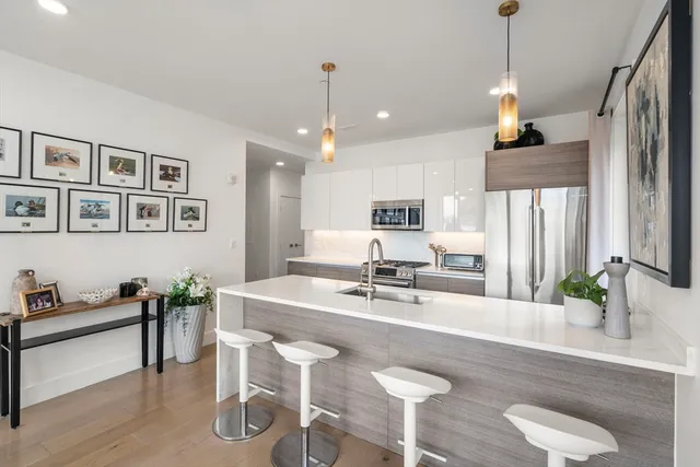 a view of kitchen island with stainless steel appliances furniture refrigerator dining table and chair