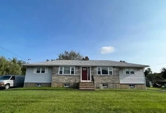 a front view of a house with a garden and yard