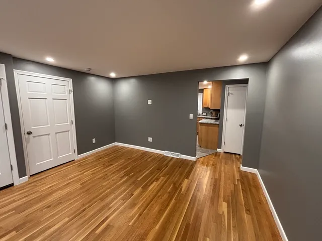 a view of empty room with wooden floor