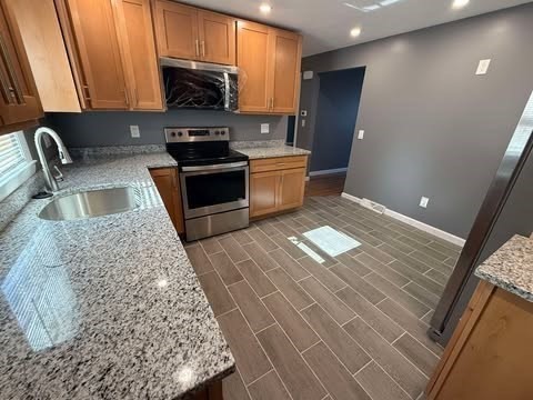 108 Reed Street, Unit R Randolph, MA 02368 - Photo 2 of 21 a kitchen with granite countertop a stove a sink and a microwave