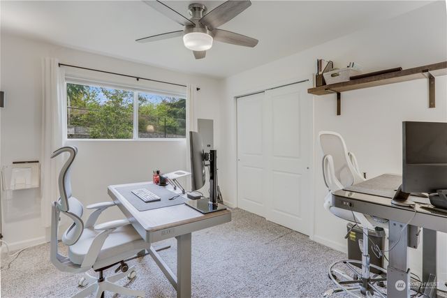 a view of a workspace with furniture and a window