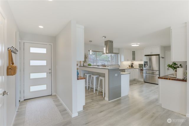 a kitchen with white cabinets and stainless steel appliances