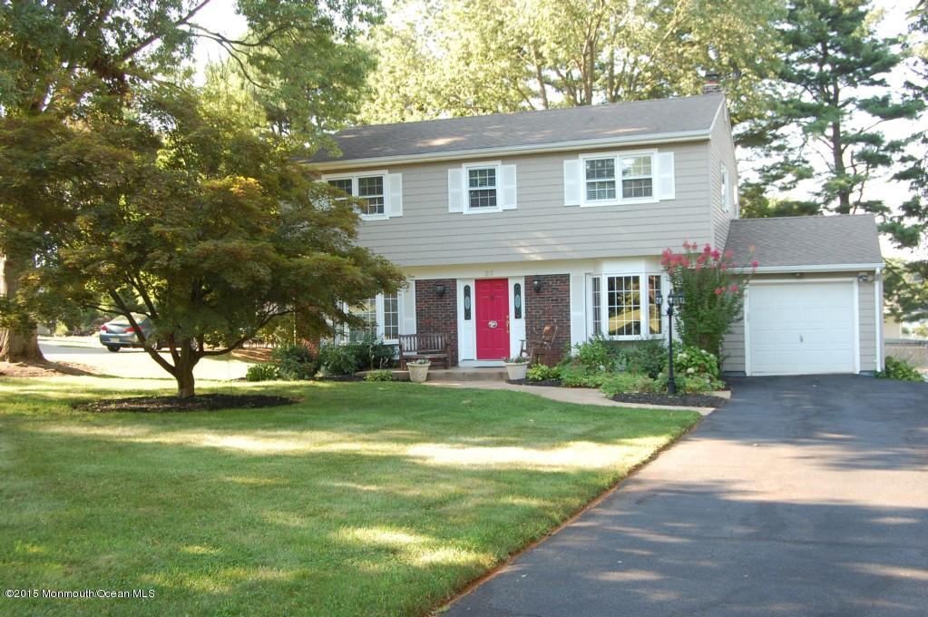 a view of a house with a yard and large tree