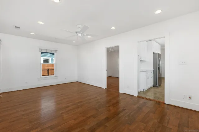 an empty room with wooden floor and windows
