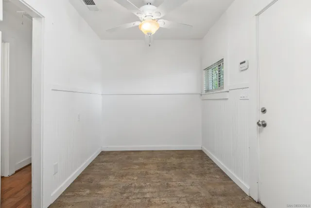 an empty room with closet and a chandelier fan