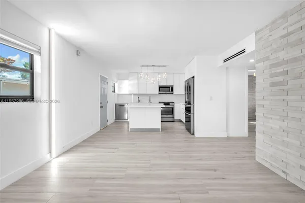 a view of a kitchen with refrigerator and white cabinets