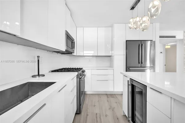 a kitchen with a sink dishwasher a stove and a refrigerator with wooden floor