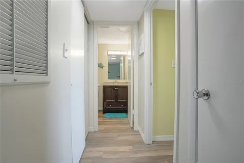 a view of a hallway with wooden floor and closet