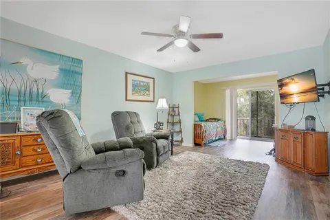 a living room with furniture and a flat screen tv with wooden floor