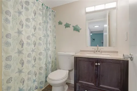 a bathroom with a granite countertop sink a toilet and a mirror