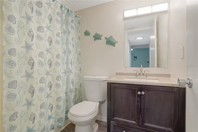 a bathroom with a granite countertop sink a toilet and a mirror