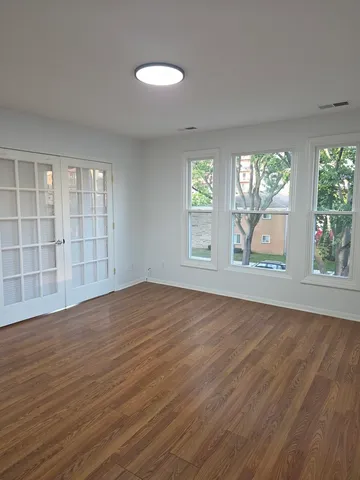 wooden floor in an empty room with a window