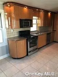 a kitchen with granite countertop a stove a sink and a microwave
