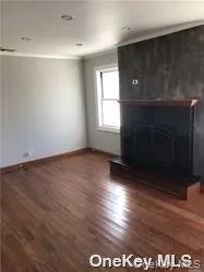 an empty room with wooden floor and fireplace