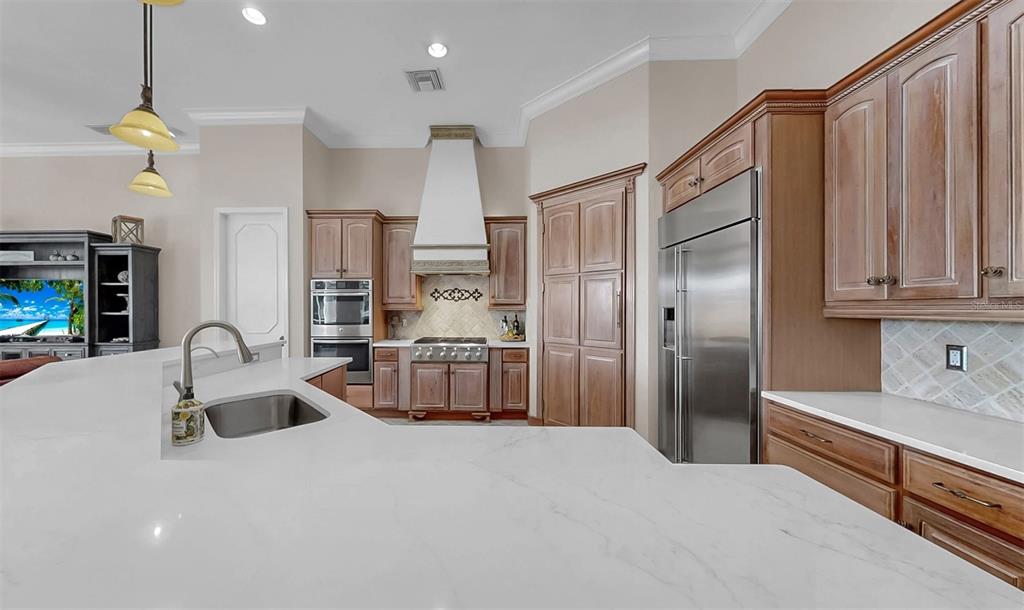 914 Capriccio Lane Apollo Beach, FL 33572 - Photo 18 of 75 a kitchen with stainless steel appliances kitchen island granite countertop a refrigerator and a sink
