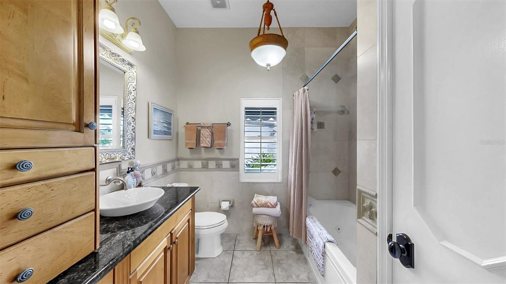914 Capriccio Lane Apollo Beach, FL 33572 - Photo 45 of 75 a bathroom with a granite countertop sink toilet a shower and a mirror