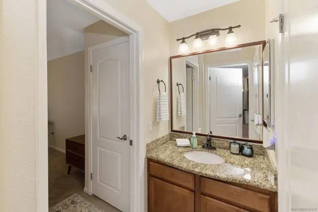 a bathroom with a granite countertop sink and a mirror