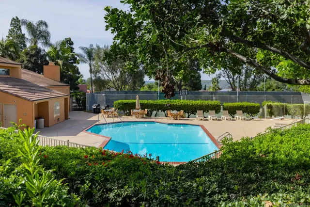 a view of a swimming pool with a patio and a yard