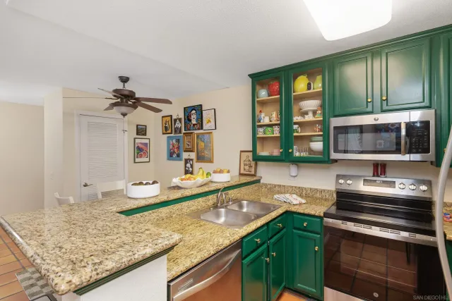 a kitchen with stainless steel appliances granite countertop a sink and a stove