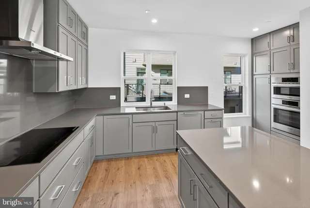 a kitchen with stainless steel appliances granite countertop a sink refrigerator and cabinets
