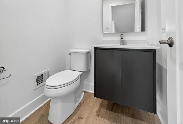 a bathroom with a toilet a sink and mirror